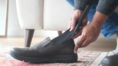  Erkek eli ayakkabının içine ortopedik taban koyuyor. .