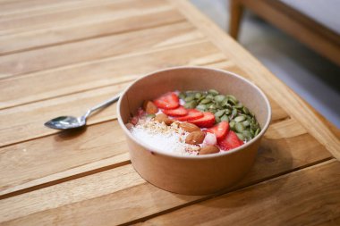 Bir kase taze çilek ve gevrek tohumlu kremalı yoğurt.