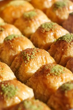 Şam fıstığı kırıntılarıyla serpiştirilmiş otantik baklava dilimlerinin tadını çıkarın.