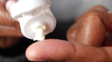 Merheme batırılmış bir parmak, mükemmel bir şekilde hazırlanmış ve cilde uygulanmaya hazır.