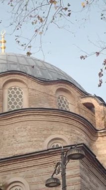 Büyük kubbeleri ve renkli gökyüzünün altında uzun minareleri olan güzel bir cami.