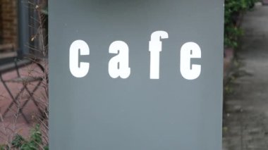 Şık ve şık bir kafe tabelâsı. Canlı bir şehir ortamında gösterişli bir tabela.