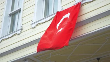 Pencerede Türk bayrağı asılı.