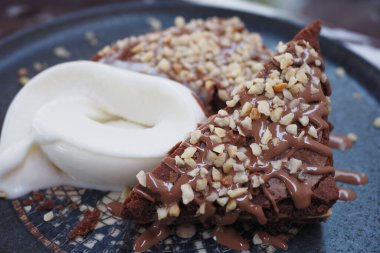 Bu çikolatalı tatlı fındıklı ve kremalı kremayla servis ediliyor.