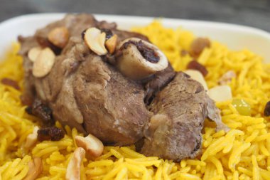 Lezzetli bir yemek için lezzetli sarı pirinç yatağında lezzetli bir kuzu inciğin tadını çıkar.