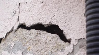 Bu, çeşitli yapısal sorunları vurgulayan çatlak bir duvar yüzeyini gösteren detaylı bir görüntüdür.