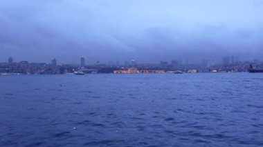 Huzurlu ve sakin bir gece sahnesi sislerin arasından zarif bir kıyı şehrini gözler önüne seriyor.