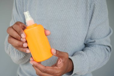 Güneş kremi tutan bir adam .