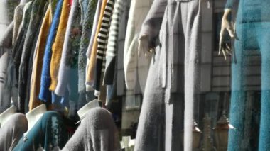 Mağaza vitrininde renkli bir kıyafet gösterisi, benzersiz stiller ve eğilimler sergileniyor