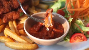 Taze salatayla servis edilen kızarmış tavuk, çıtır patates kızartması ve lezzetli bir sos..