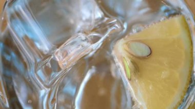 Buzlu, ferahlatıcı ve canlandırıcı bir bardak soğuk su ve bir dilim taze limon.
