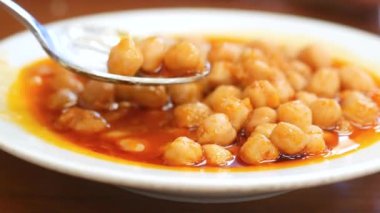 Zarif, lezzetli bir sosla kaplanmış baharatlı nohutlarla dolu canlı bir tabak.