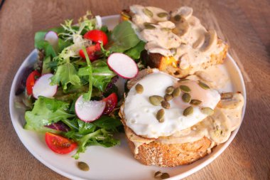 Lezzetli yumurtalar, çıtır tost ve taze, canlı bir salatanın tadını çıkarın.