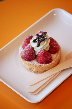 Taze çilek ve kremayla kaplanmış nefis bir turta.