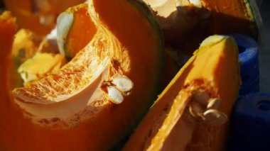 Canlı ve parlak turuncu balkabağı dilimleri eşsiz tohumlarını ve karmaşık dokusunu sergiliyor.