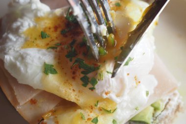 Haşlanmış yumurtalar, taze otlar ve çıtır çıtır kızarmış ekmeklerden oluşan ağız sulandırıcı bir yemek.