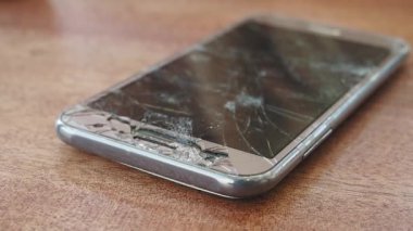 Renk arkaplanındaki bozuk akıllı telefonun üst görünümü.