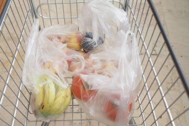 Canlı, taze meyve ve sağlıklı sebzelerle dolu bir market arabası.