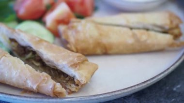 Taze bahçe salatası ve lezzetli soslu gevrek böreklerimizin tadını çıkarın.