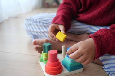 Bir çocuk, motor becerilerini ve koordinasyonunu geliştiren renkli oyuncaklarla neşe içinde oynar.