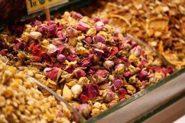 Hareketli bir pazarda, canlı kurumuş gül yaprakları ve otlar keşfedin, güzelce yerleştirilmiş.