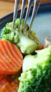 Canlı renklerini ve besinlerini vurgulayan taze brokoli ve parlak havuçlardan oluşan bir yakın plan.