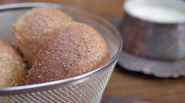 Lezzetli ve kızarmış hamur topları kremalı yoğurdun yanında servis ediliyor.