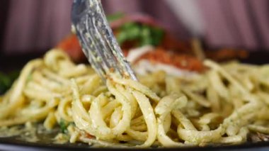 Lezzetli bir spagetti çatalla güzelce kıvrılmış, yemek tutkunları ve aşıklar için mükemmel.