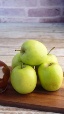 Cam şişede elma sirkesi ve masada taze yeşil elma. ,