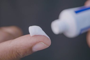 Merheme batırılmış bir parmak, mükemmel bir şekilde hazırlanmış ve cilde uygulanmaya hazır.