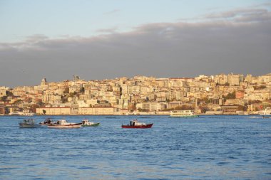 Balıkçı tekneleri, nefes kesen İstanbul siluetine karşı zarif ve zarifçe konumlandırıldı.