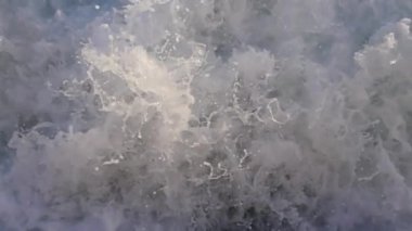 Okyanus dalgaları beyaz köpükle çarpar, doğanın ham enerjisini ve ihtişamını yakalar.