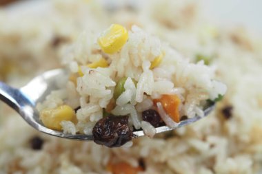 Bir kaşık dolusu lezzetli ve iştah açıcı sebzeli pirinç yemeğinin detaylı bir yakın çekimi.