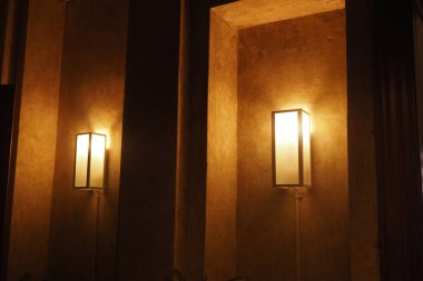 Stil duvar lambaları sıcak, dokulu bir arka plan aydınlatır, genel zarafeti artırır