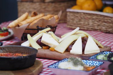 Çekici bir peynir tabağı. Ekmek çubukları ve güzel bir masaya batırılmış soslar.