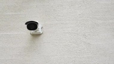 Duvara monte edilmiş bir güvenlik kamerası çeşitli ihtiyaçlar ve mekanlar için kapsamlı bir gözetim sağlıyor.