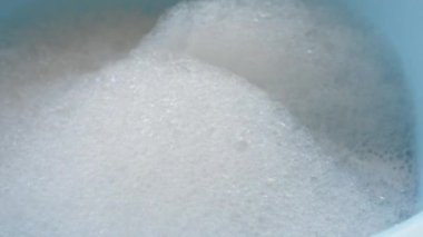 Sakin mavi bir havzada köpüklü köpüklerin yakınlaşması sakin bir atmosfer yaratır.