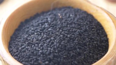 Kara tohumların yavaş çekimde kaseye düşüşü. .