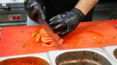 Meşgul bir mutfakta, yetenekli bir şef ustalıkla olgun, sulu domatesleri büyük bir titizlikle dilimler.