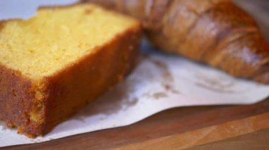 Büyüleyici, ahşap bir yüzeyde gevrek bir kruvasanla dejenere olmuş bir pasta diliminin tadını çıkar.