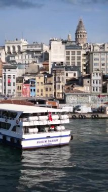 İstanbullar göz kamaştırıcı ufuk çizgisinde ikonik Galata Kulesi ve sakin sularda bir feribot yer alıyor.