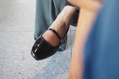 Klasik bir siyah Mary Jane ayakkabısının yakın çekim görüntüsü şık ve şık bir atmosferde sergileniyor.