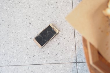 Zemindeki kırık akıllı telefonun üst görünümü .