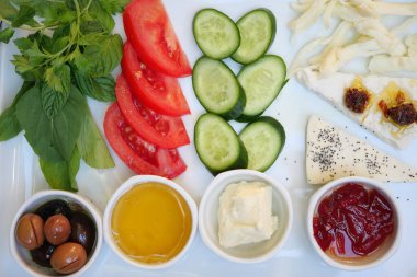 Renkli bir Akdeniz kahvaltı tabağı, taze sebzeler ve çeşitli lezzetli soslar.