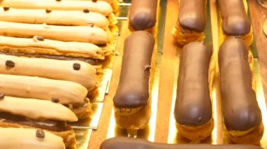 A visually enticing and tempting display of decadent chocolate eclairs and rich cream pastries