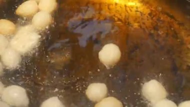 Lezzetli hamur topları kızgın yağda kızarıyor, tadını çıkarmaya hazır.