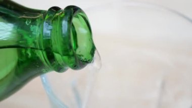 Ferahlatıcı ve köpüklü bir köpüklü su zarif bir şekilde temiz bir bardağa dökülüyor.