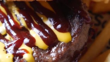 Barbekü sosu ve hardalla süslenmiş lezzetli, ağız sulandıran bir hamburger.