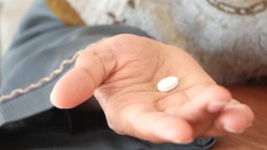 bir hap elinde tutan kadın,