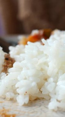 Temiz beyaz tabakta servis edilen nohutla süslenmiş baharatlı tavuklu pilav tabağı.